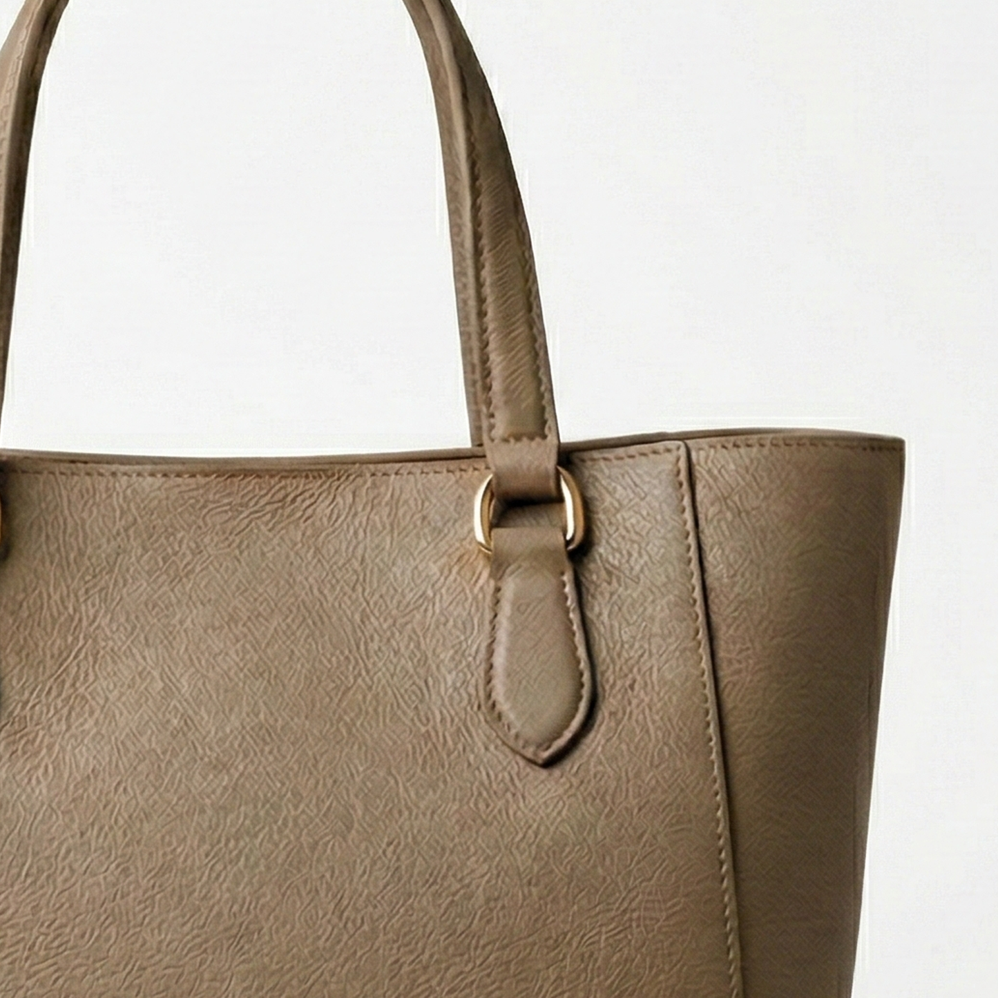 Beige handbag with a gold buckle on a light gray background